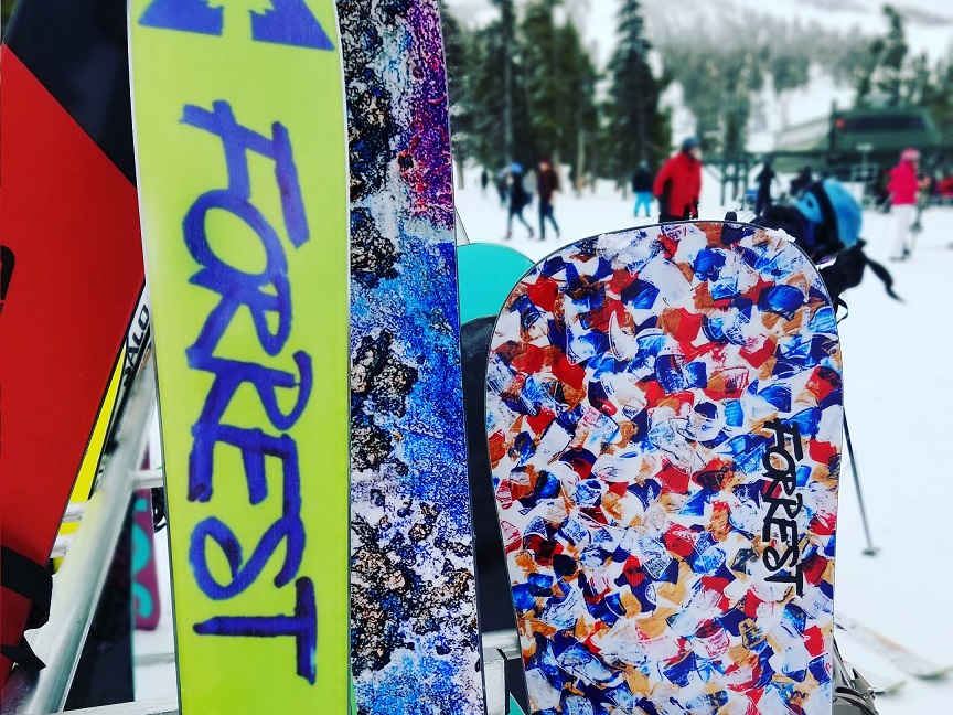designer skis and snowboard on slopes