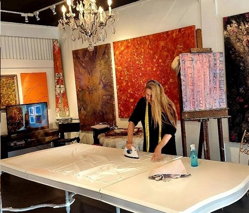 designer kim gayner preparing fabrics on a table inside an art gallery